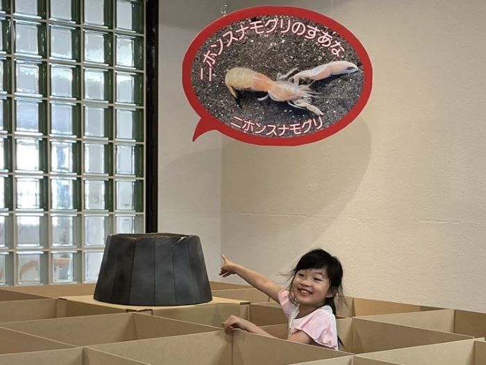 巣穴を指さす子どもの画像